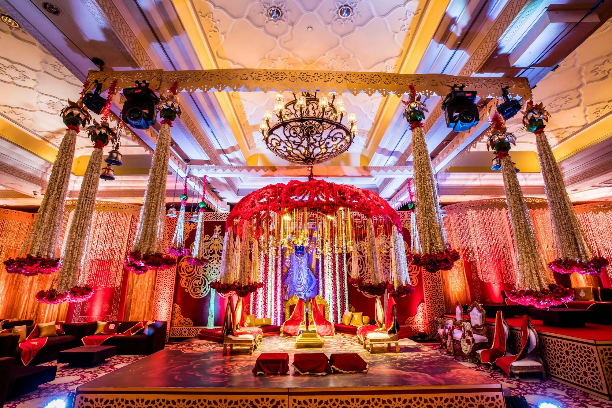 Opulent red and gold wedding stage with chandelier