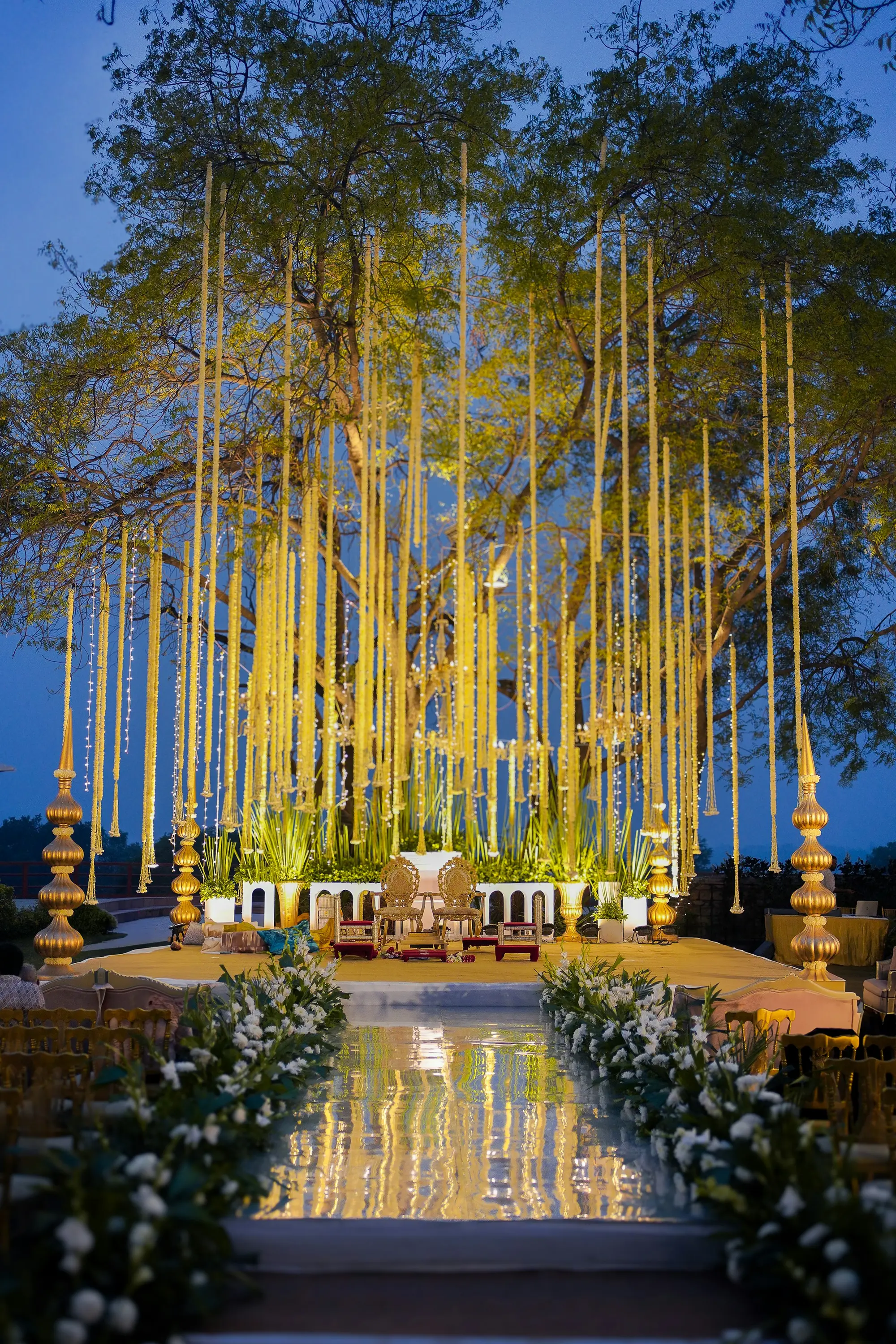 Mandap of hanging yellow floral strands at dusk