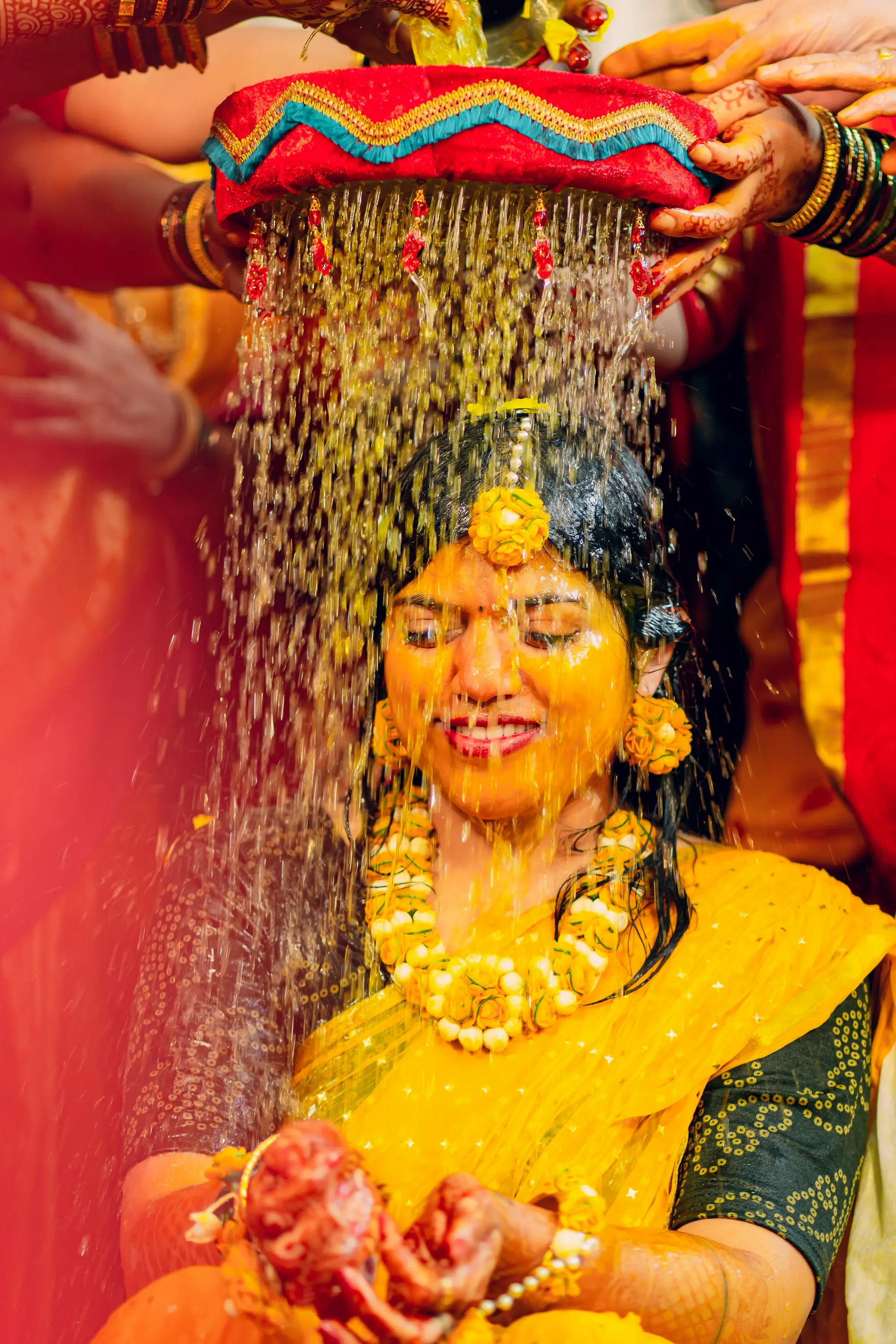 Bride showered with flower petals during haldi