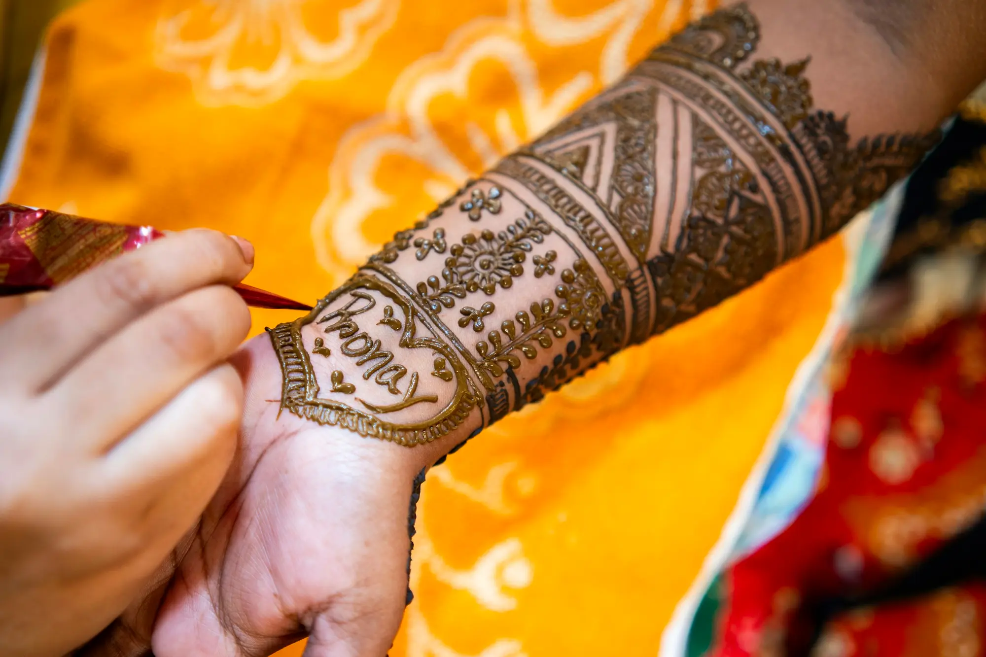 Artist applying intricate mehendi on a bride's hand