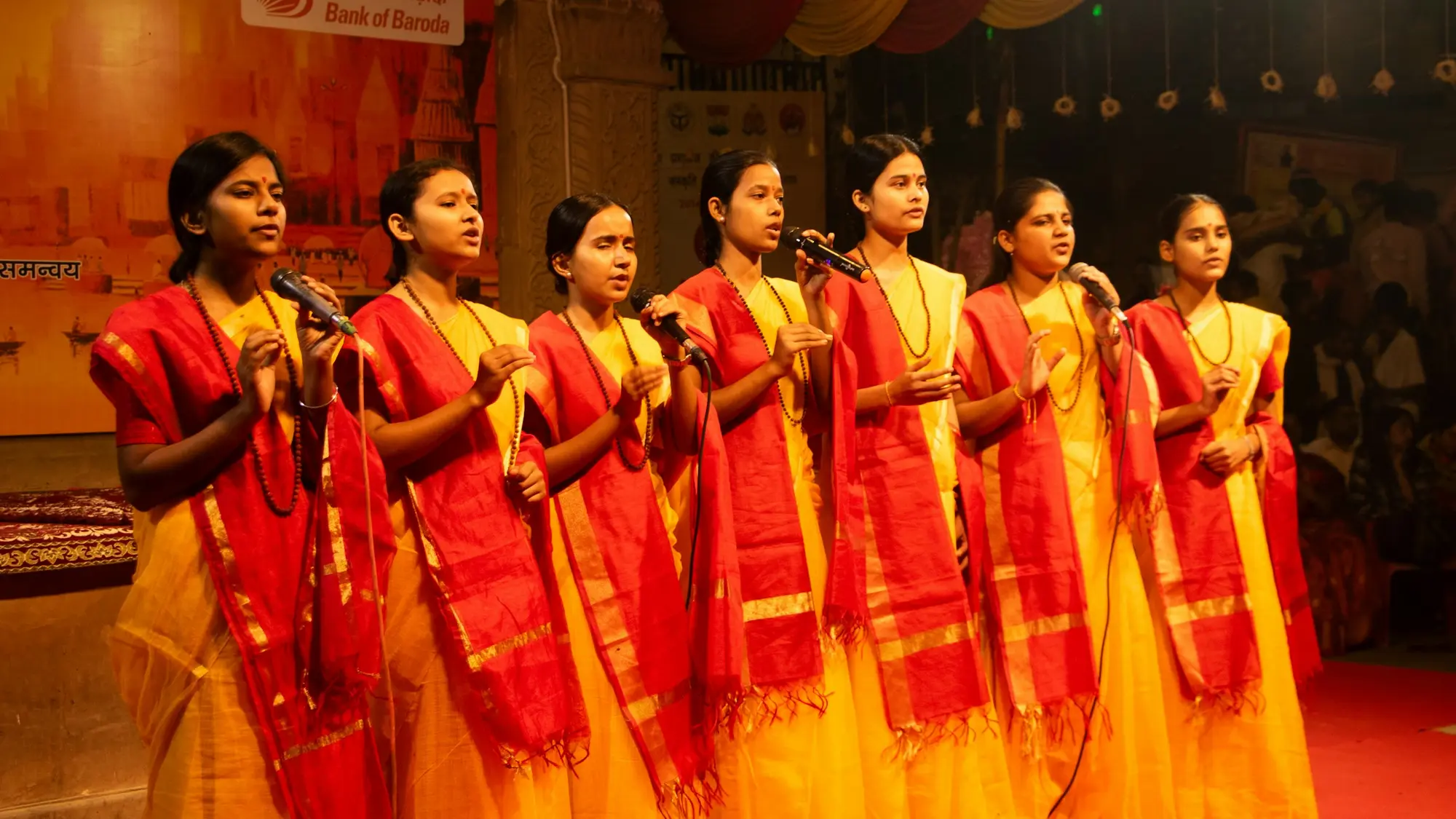 Group of women in red and gold performing on stage