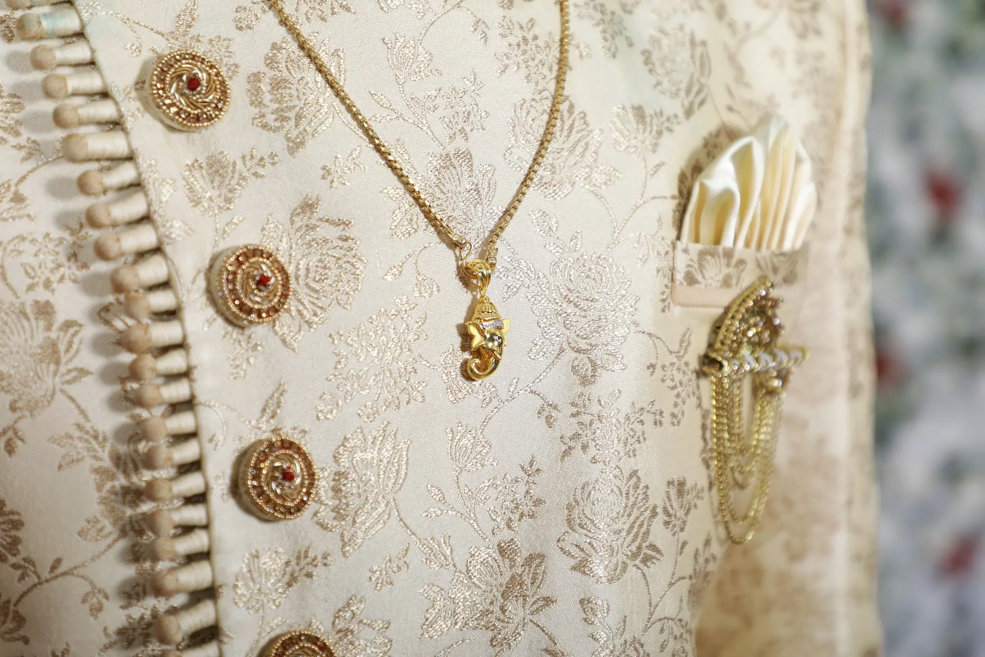 Gold zari embroidered sherwani with a layered necklace