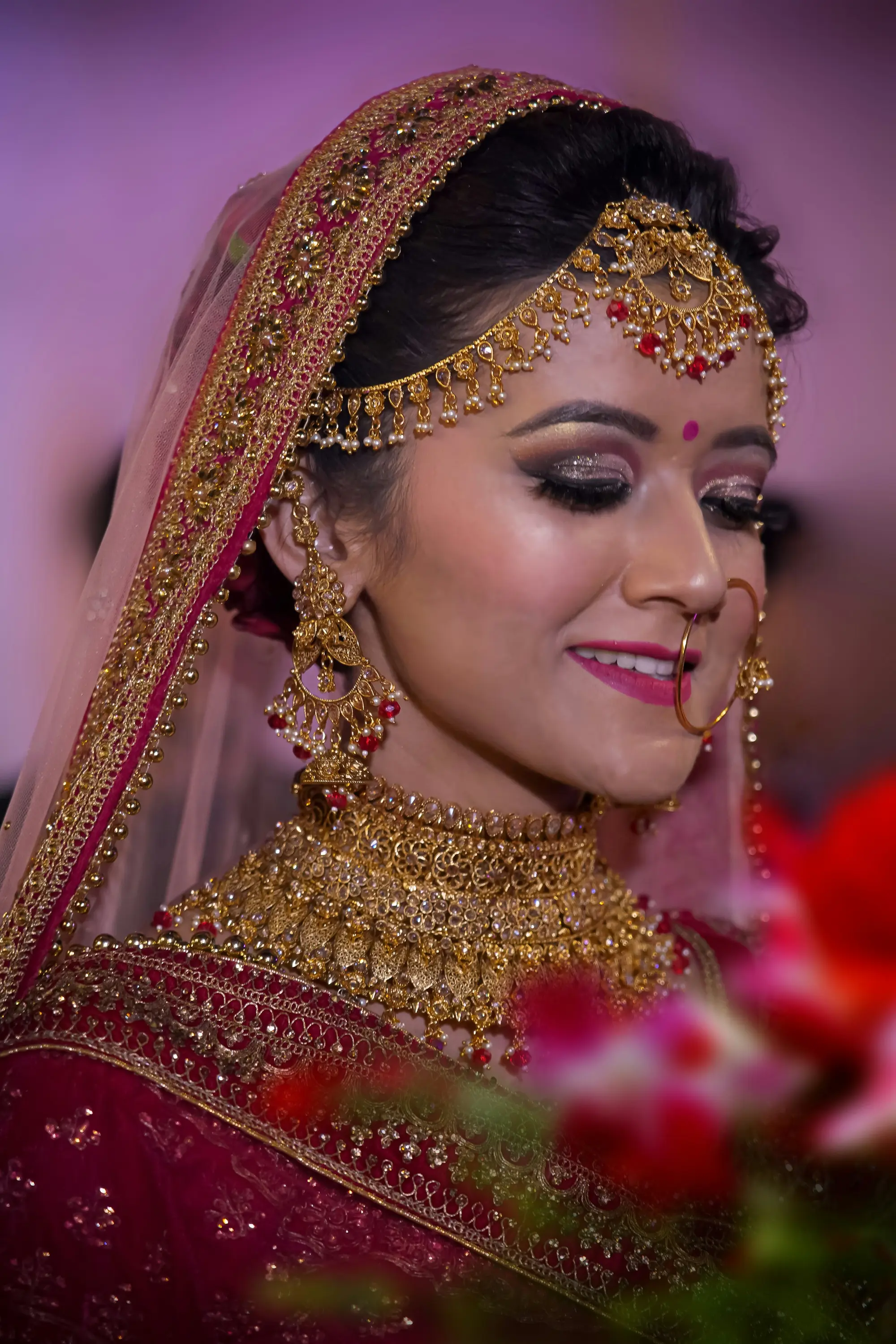 Smiling Indian bride wearing kundan jewellery and maang tikka