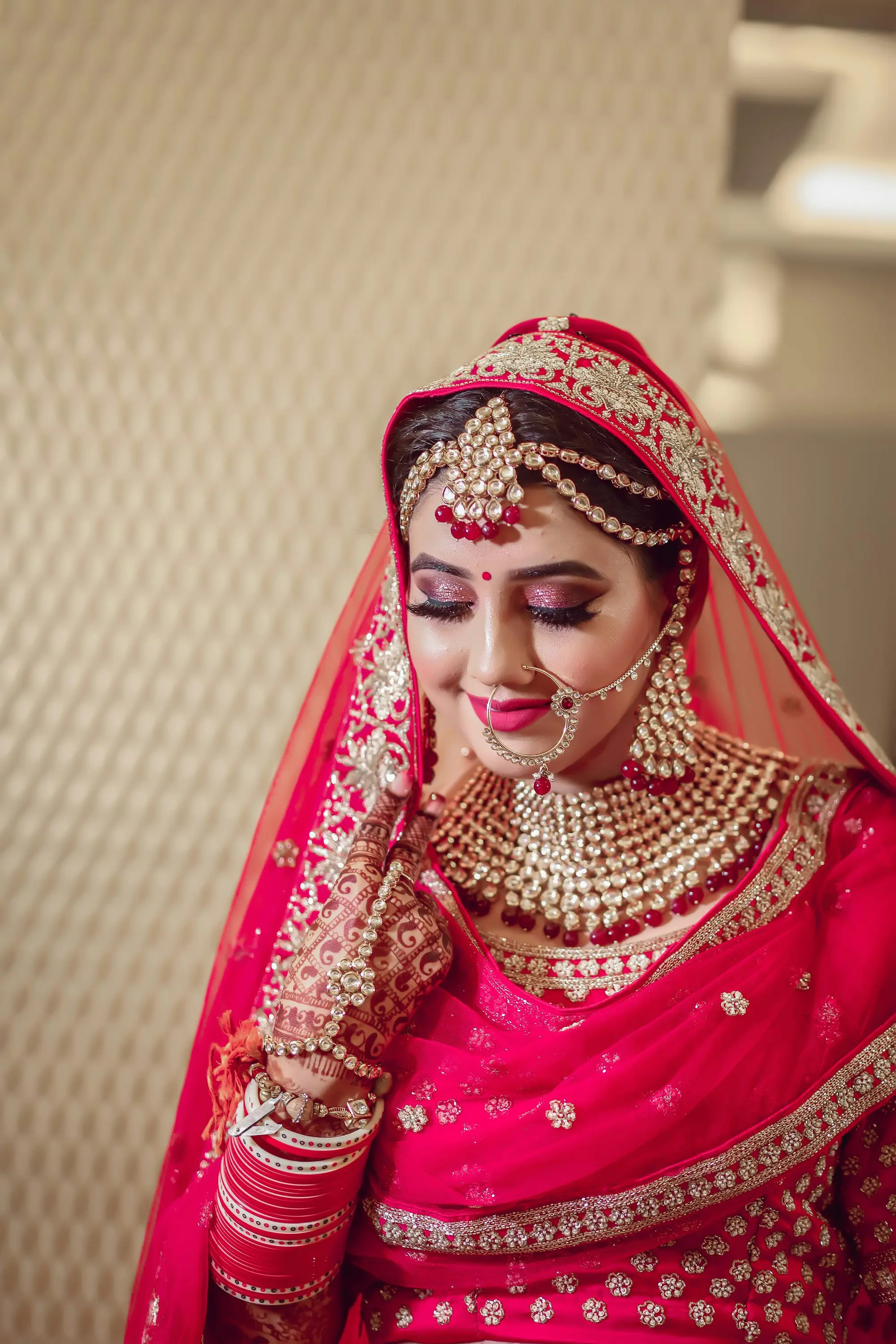 Indian bride in red bridal lehenga and gold jewellery